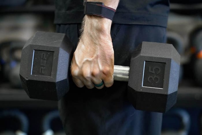 A person holding a Rep dumbbell