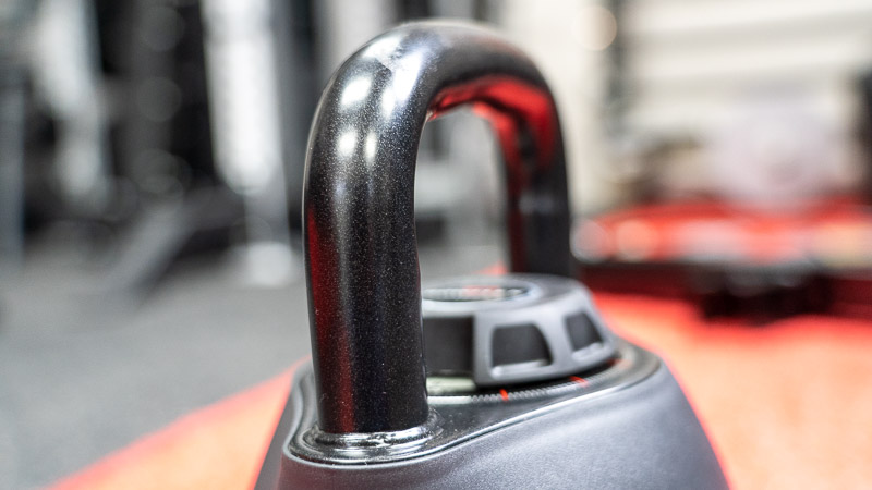 Up close photo of the shiny handle on the kettlebell.