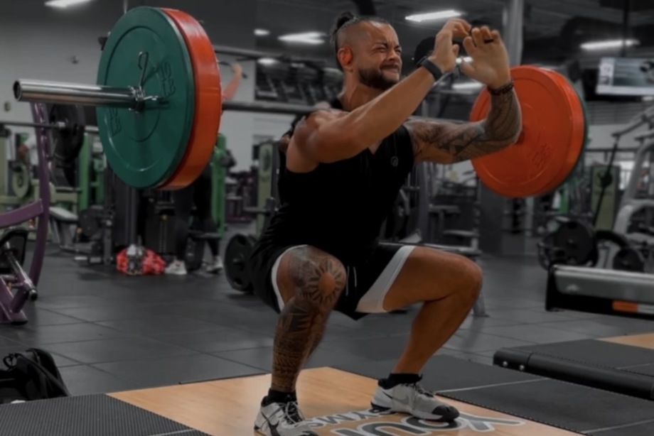 Stephen doing barbell front squats in a gym