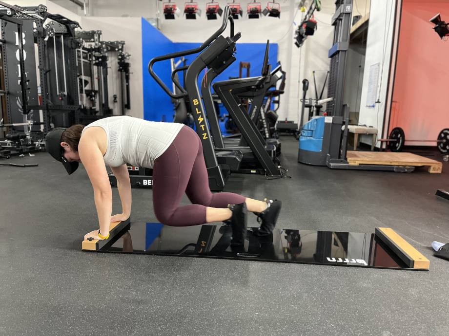 A woman using a Brrrn Board while leaning on her hands