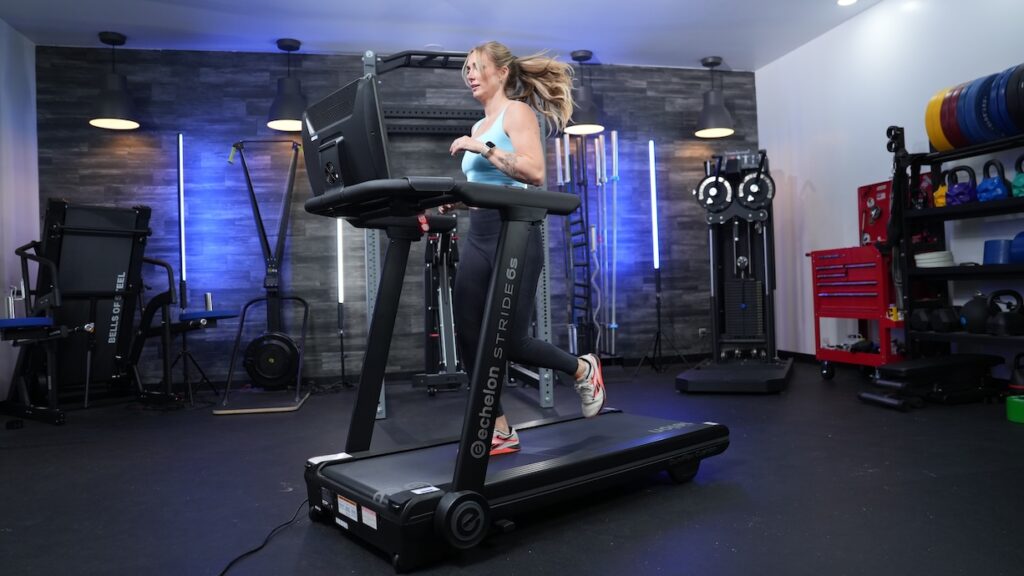 A woman running on the Echelon Stride-6s treadmill in a workout studio.