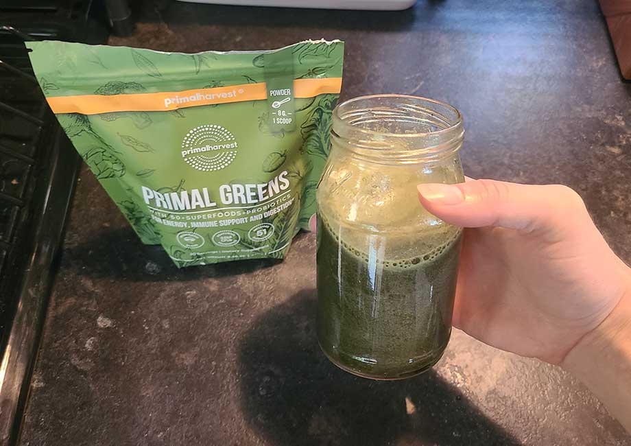 https://www.garagegymreviews.com/wp-content/uploads/COVER-IMAGE-holding-a-glass-of-primal-greens.jpg