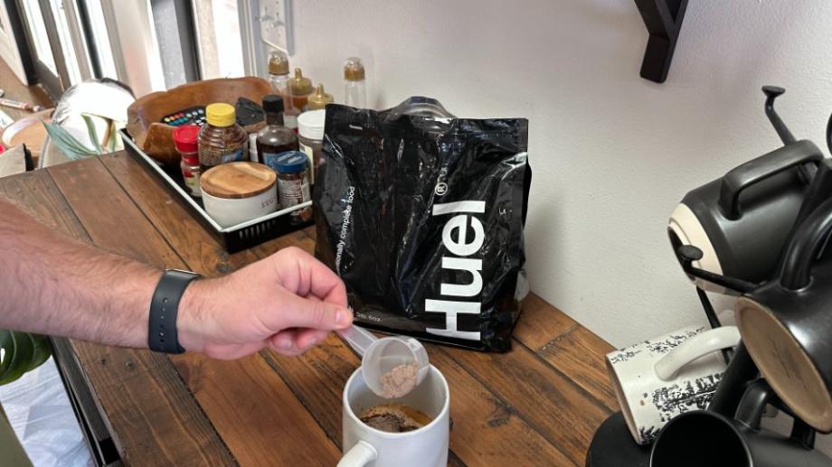 Man using Huel Black Edition in his coffee