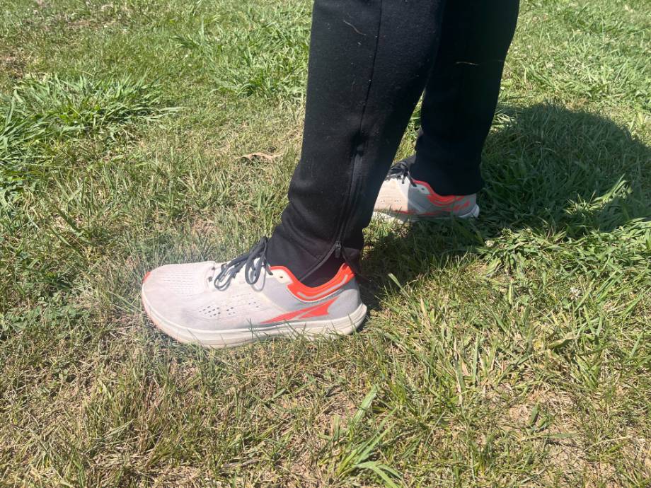 A person stands in grass wearing a pair of Altra Provision 8 shoes.