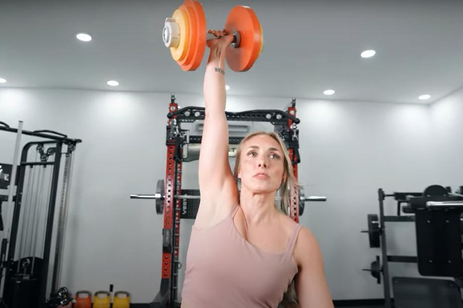 Lindsay Scheele, CPT performs a dumbbell snatch with an Aviron Loadable Dumbbell.