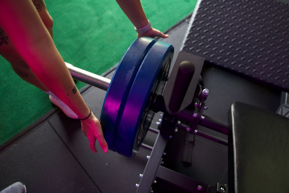 Looking down at weight plates being loaded onto a Bells of Steel Hip Thrust Machine