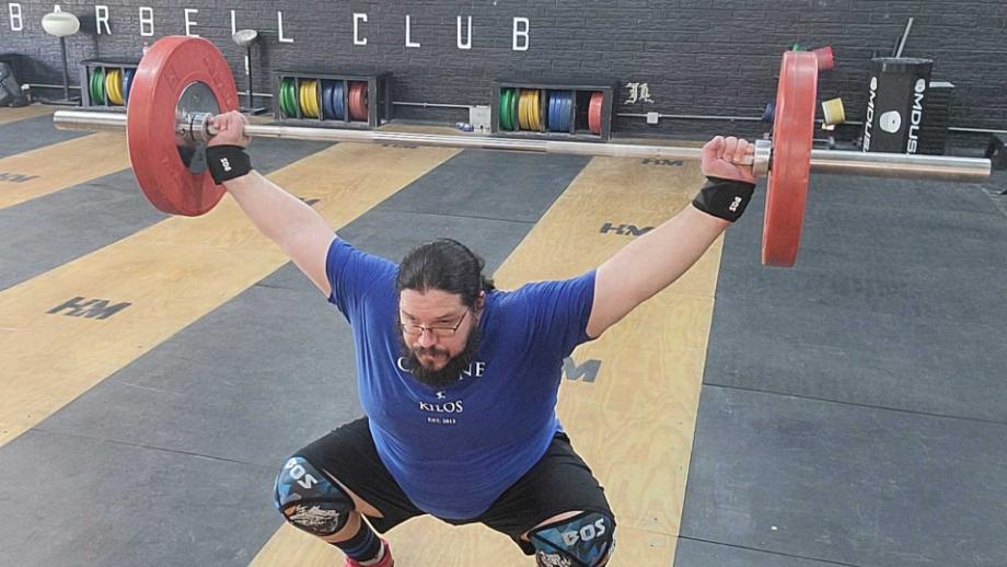 Man performing a snatch using the Bells of Steel Mighty Wrist Wraps and Knee Sleeves