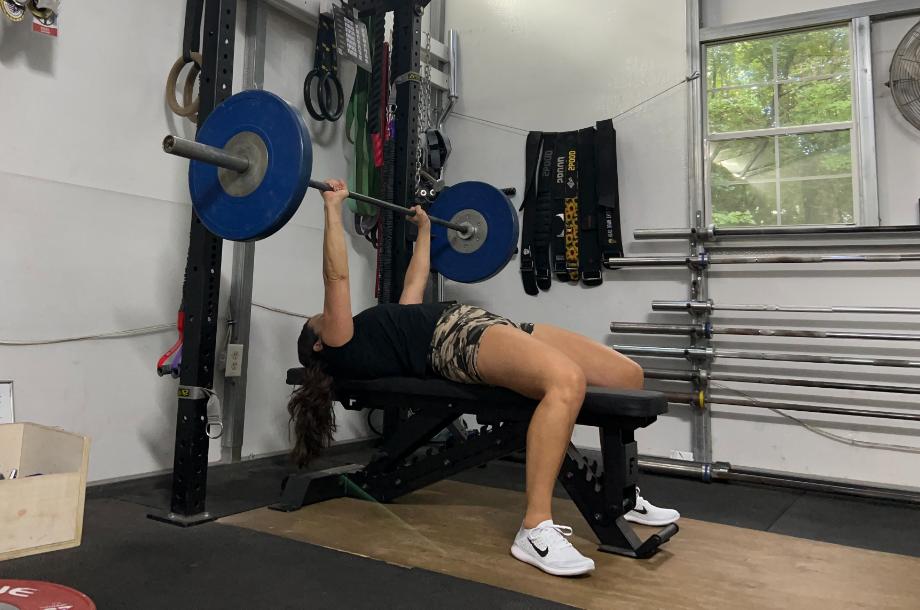 Woman benching using the Force USA Pro Series FID Bench