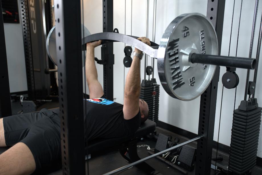 Coop performs bench press with a cambered Swiss bar on the Body-Solid Functional Trainer Rack