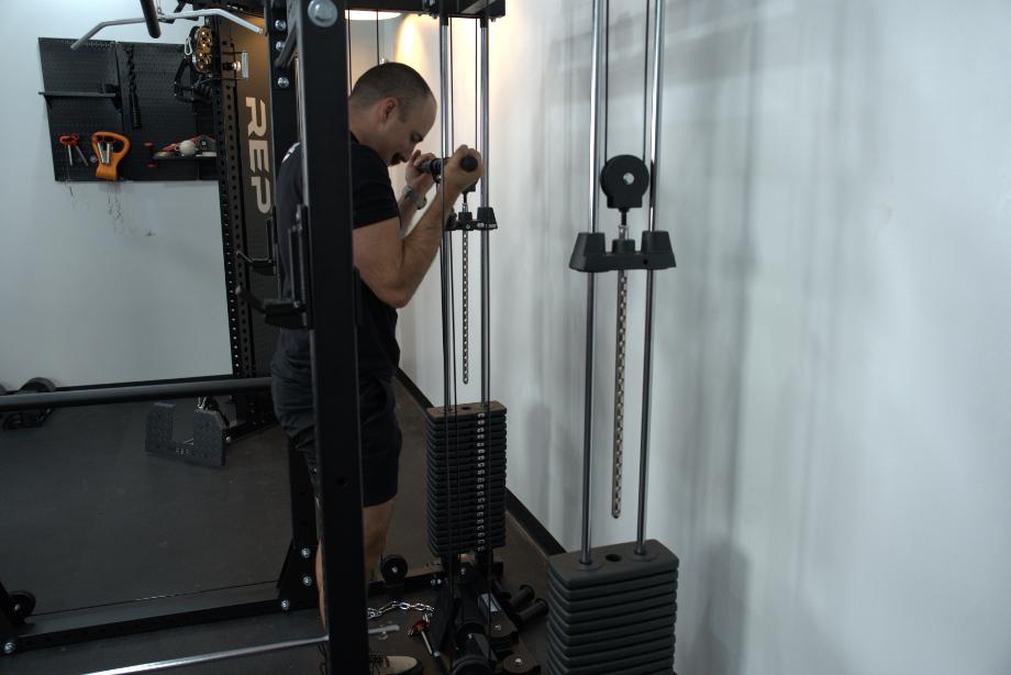 Man performing cable biceps curls on the Body-Solid Functional Trainer Rack