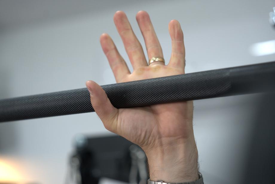 Man about to grip the pull-up bar of the Body-Solid Functional Trainer Rack