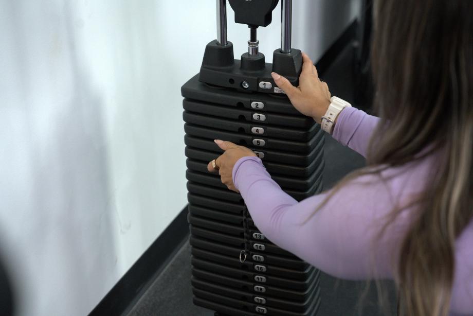 Woman adjusting the weight stack on the Body-Solid Functional Trainer Rack