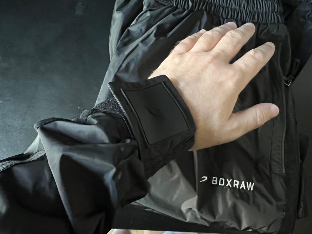 Close-up of a man's hand and the Velcro straps on the Boxraw Sauna Suit