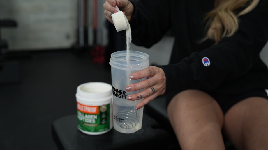 Dumping scoop of Bulletproof Collagen Peptides into a shaker bottle