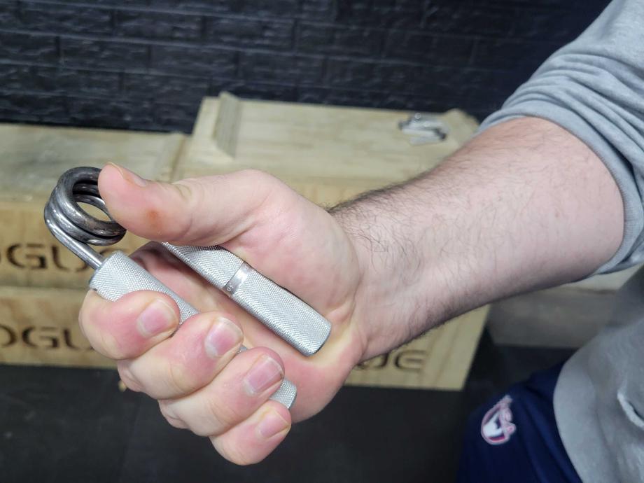 Olympian Caine Wilkes demonstrates the grip of the worthy using an Ironmind Captains of Crush grip strengthener.