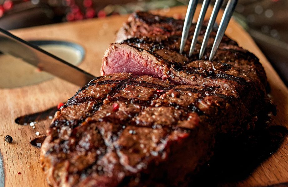 A close look as a knife slices into a rare steak