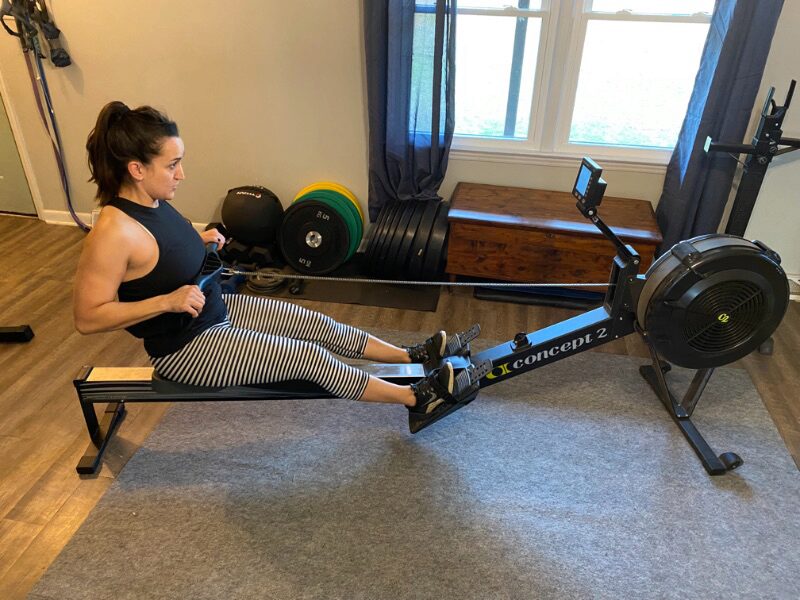 Woman using the Model D Concept 2 Rower in her living room
