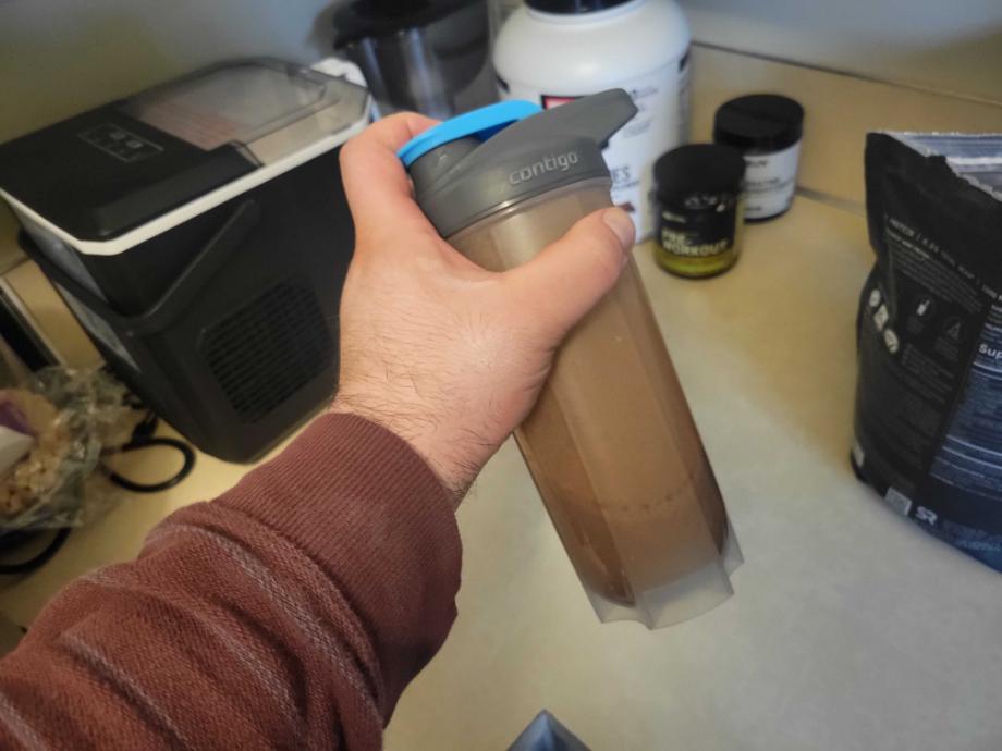 A person shaking a protein drink in the Contigo Shaker Bottle