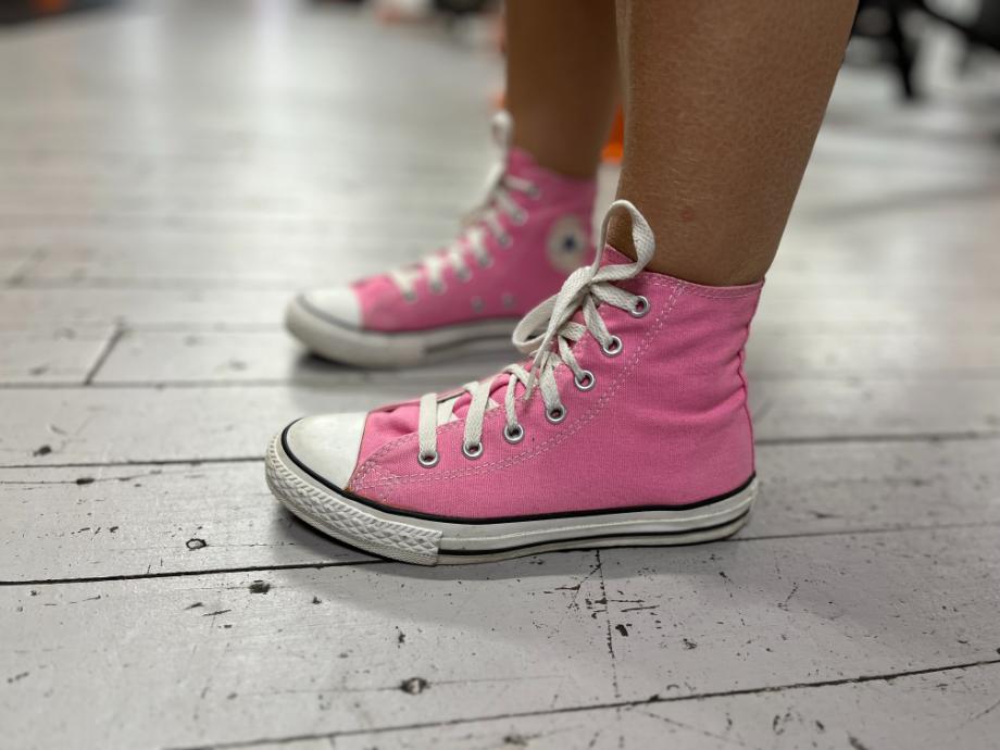 Woman wearing pink converse chuck taylor all-star high-top shoes