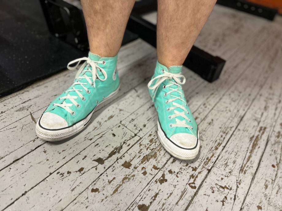 man wearing converse chuck taylor in teal