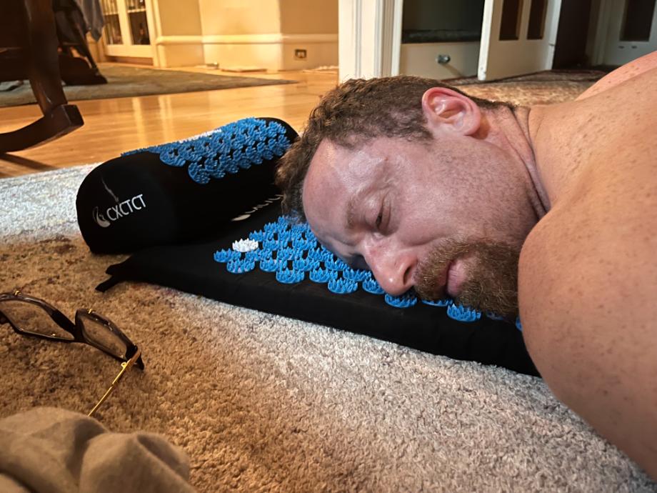 A person lying face down on a CXCTCT Acupressure Mat.