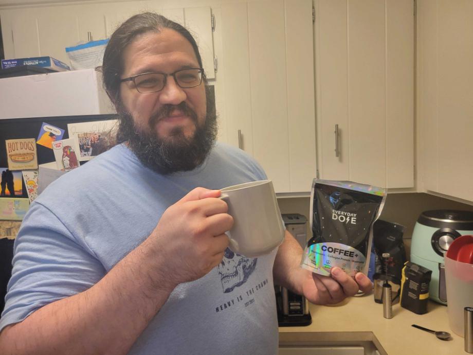 Olympian Caine Wilkes holds up a cup and bag of Everyday Dose Mushroom Coffee.