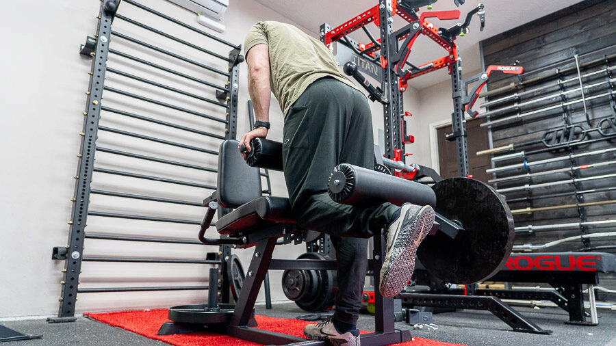 Rear view of Coop using Titan Seated Leg Curl/Extension machine 