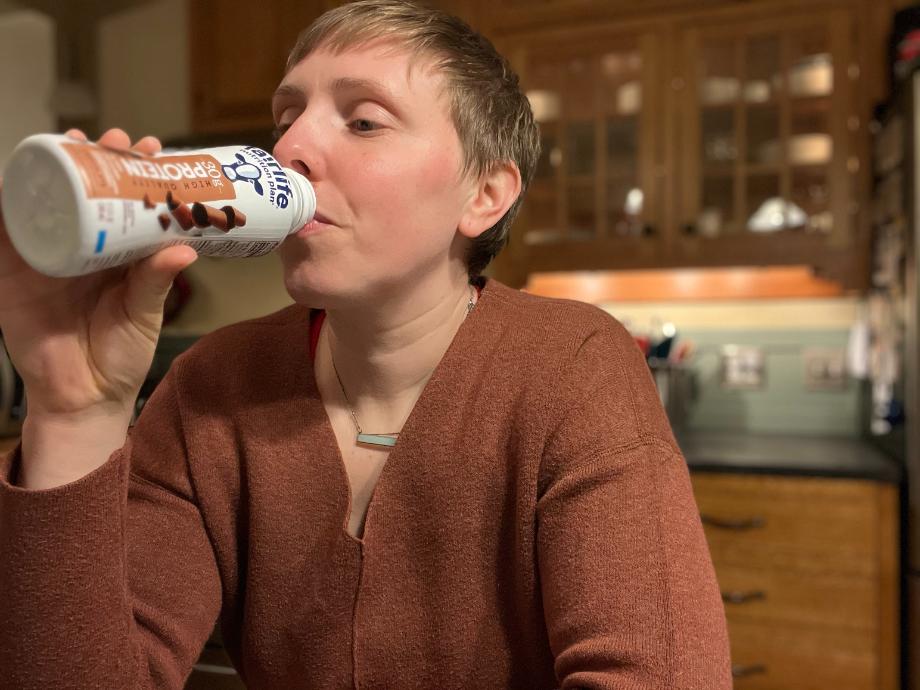 A woman drinks a Fairlife Nutrition Plan Shake.