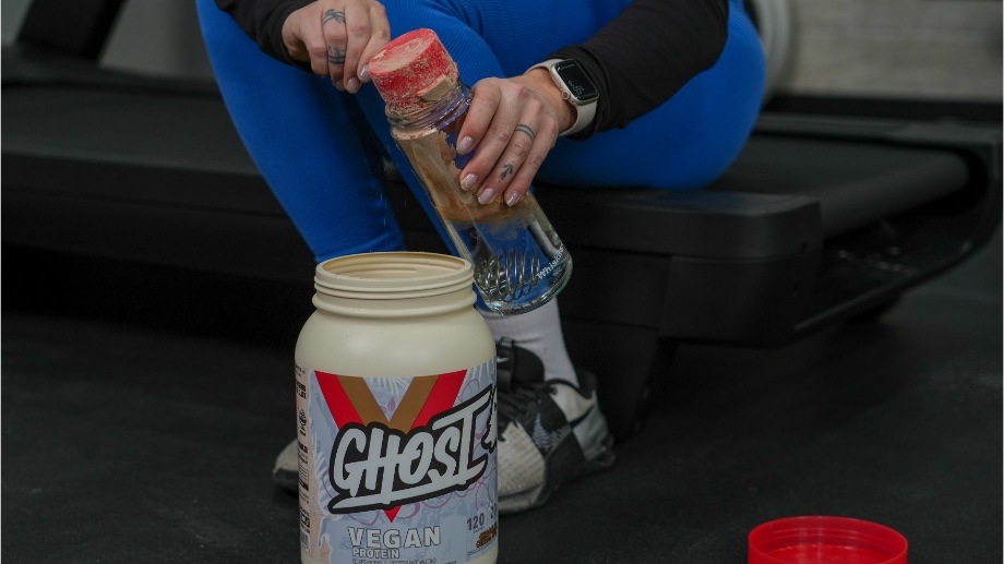 A person mixing a shake with Ghost Vegan Protein.