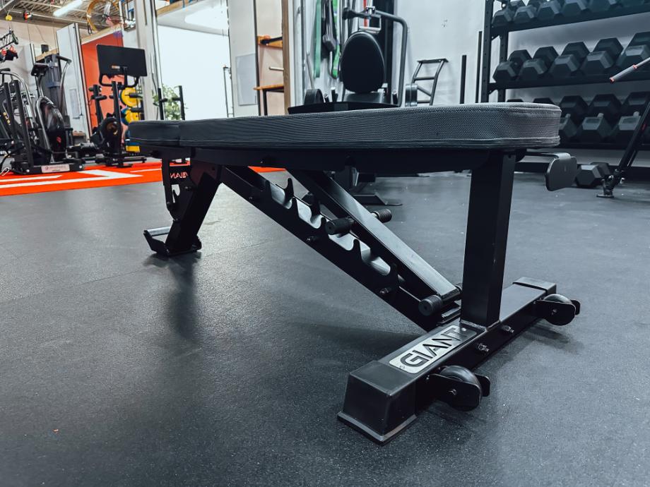 A close look at a Giant Lifting Adjustable Weight Bench in a gym