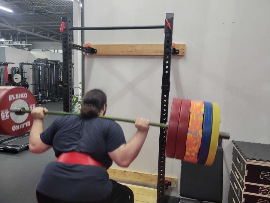 Man squatting in front of the Giant Lifting Wall Rack 2.0