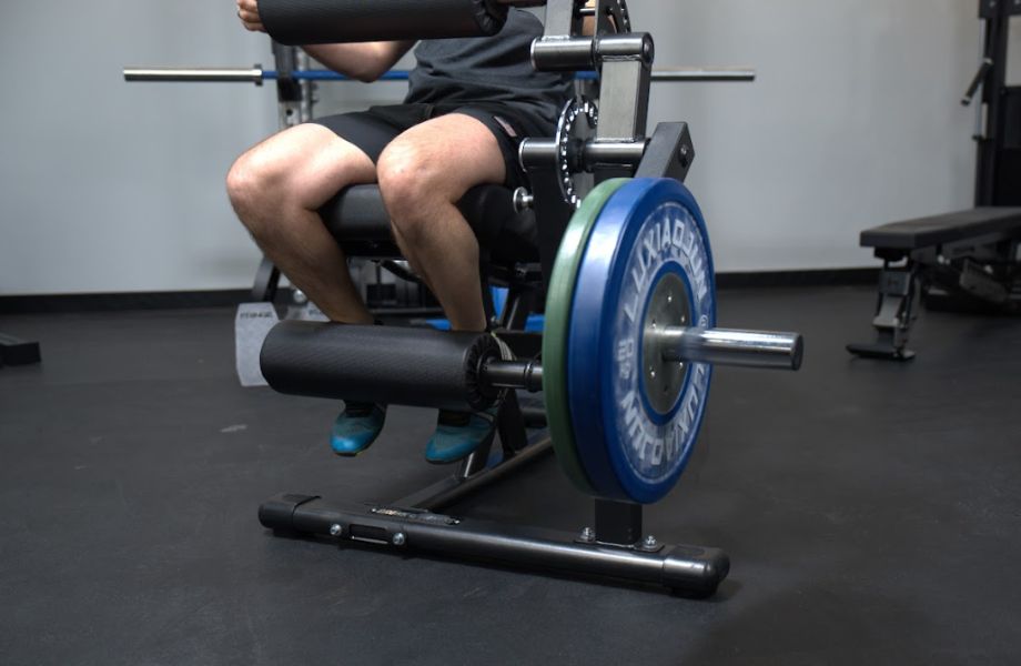 Coop doing leg extensions on the Gronk Fitness Leg Machine