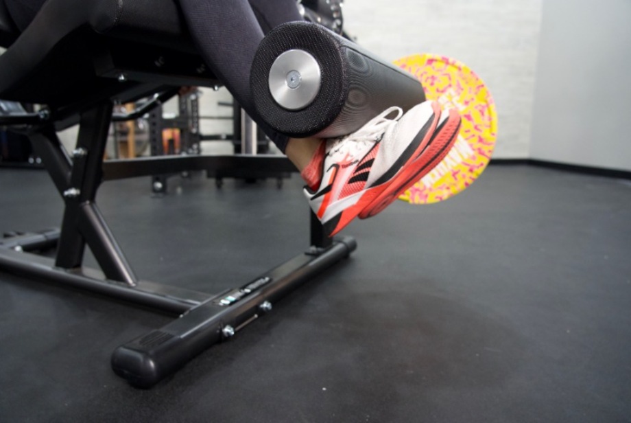 A close look at the padding while a person does leg extensions on the Gronk Fitness Leg Machine.