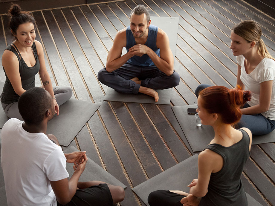 group-of-people-having-discussion-on-yoga-mats