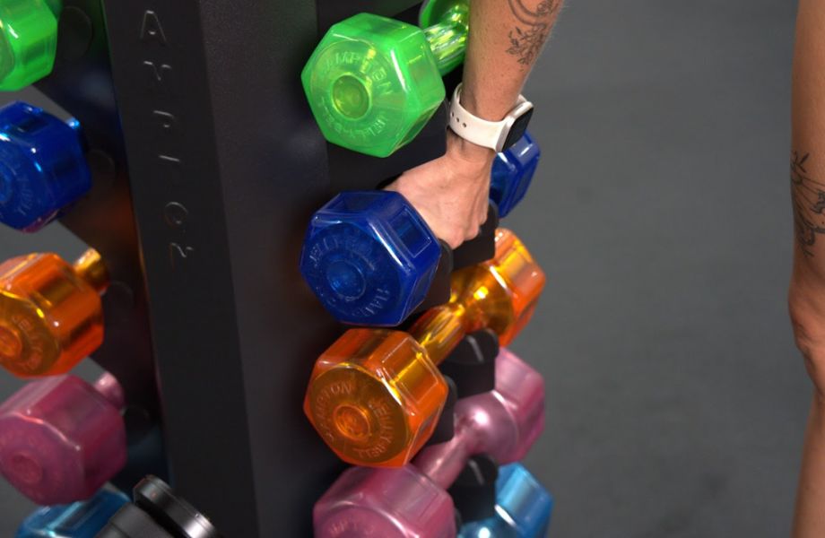 Person gripping dumbbell from Hampton Jelly Bell weight rack