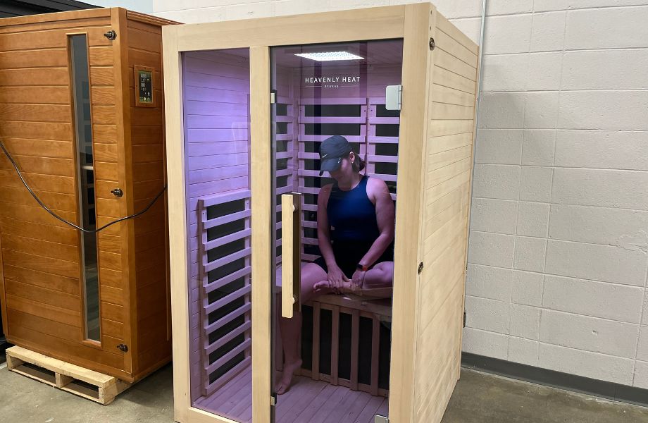 Woman sitting inside the Heavenly Heat infrared sauna with chromotherapy lights