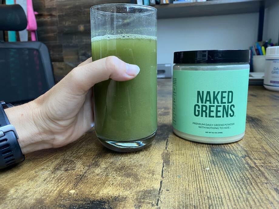 https://www.garagegymreviews.com/wp-content/uploads/holding-a-glass-of-naked-greens-powder-with-water.jpg