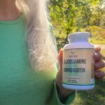 A woman with silver hair holds up a bottle of Double Wood Glucosamine Chondroitin