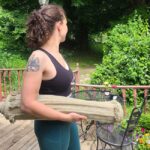 Woman holding a rolled up Oko yoga mat under her arm