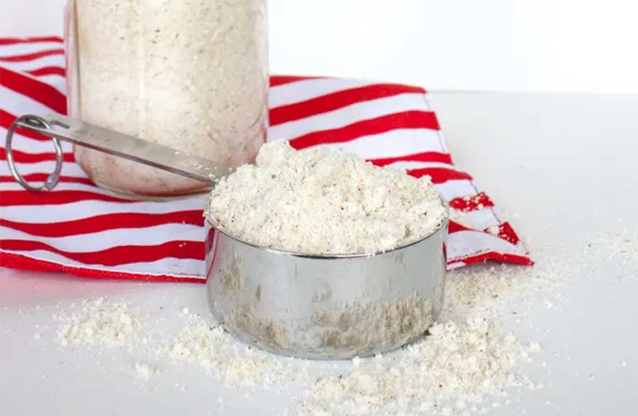 Homemade protein powder in a jar and measuring cup.