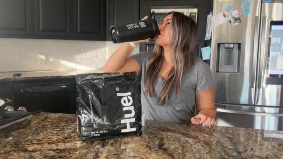 Woman drinking Huel Black Edition