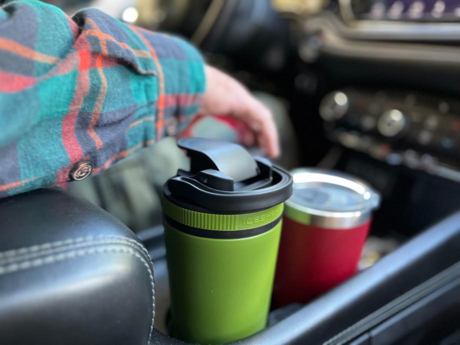 An Ice Shaker bottle rests in a car's cup holder