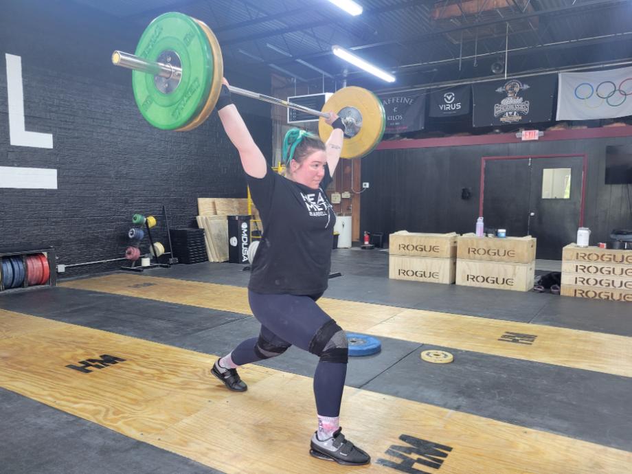A woman performs a jerk with kcross Weightlifting Shoes.
