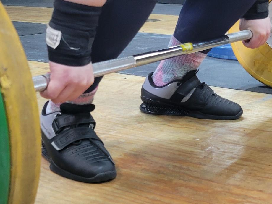 A person get set up to lift with kcross Weightlifting Shoes.