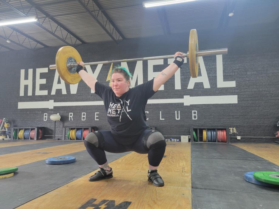 A woman performs a snatch with kcross Weightlifting Shoes.