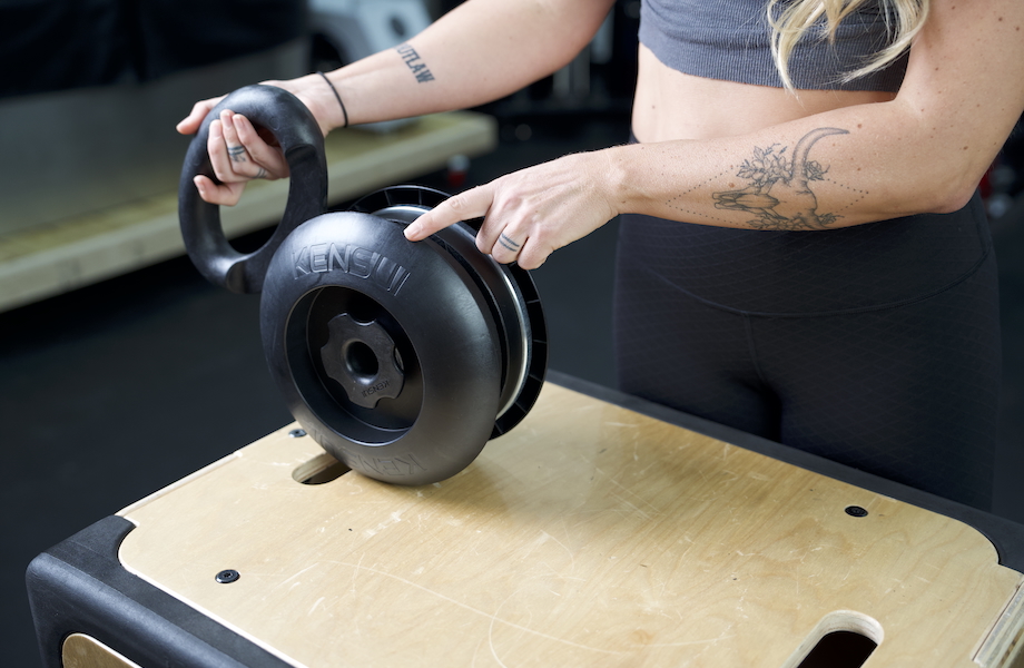 Lindsay Scheele holding the Kensui EZ-BELL MAX on top of a plyo box.