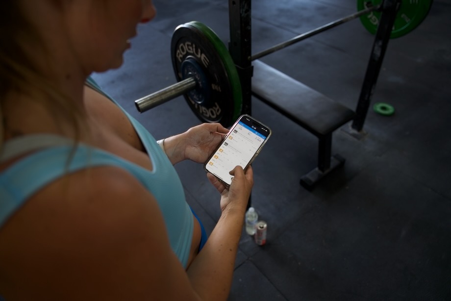 Looking over Lindsay's shoulder while she scrolls through the Legion Fitness App.