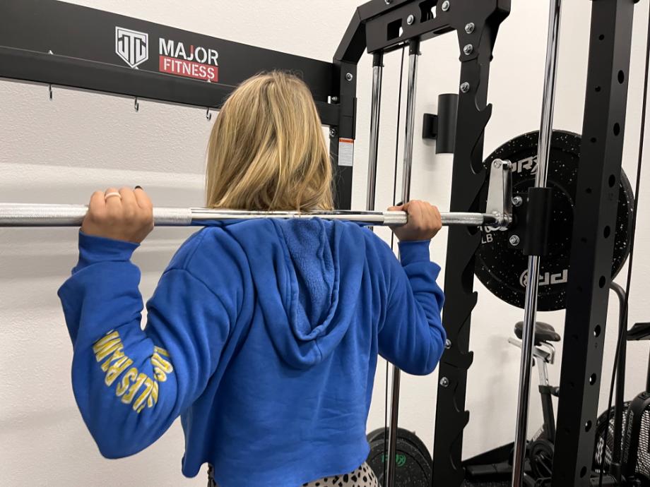 Woman using smith machine feature in Major Fitness All In One Power Rack F22 fitness social media