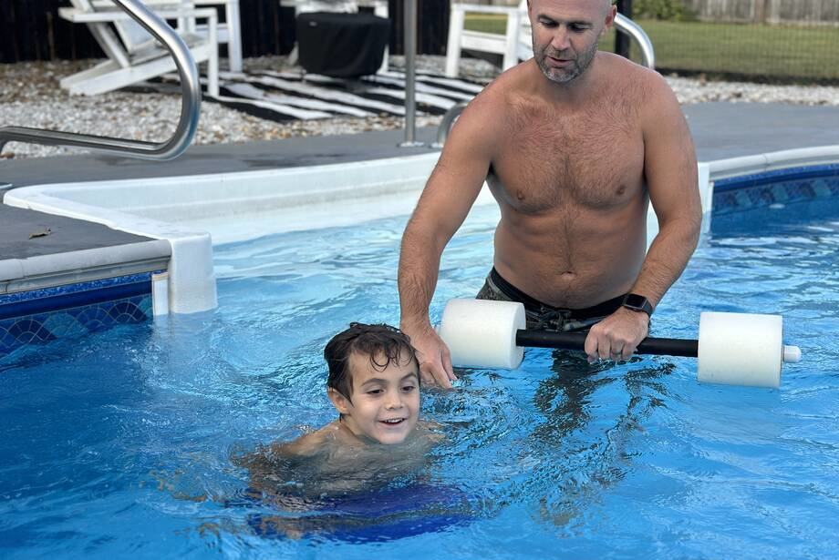 Man holding a Theraband Swim Bar