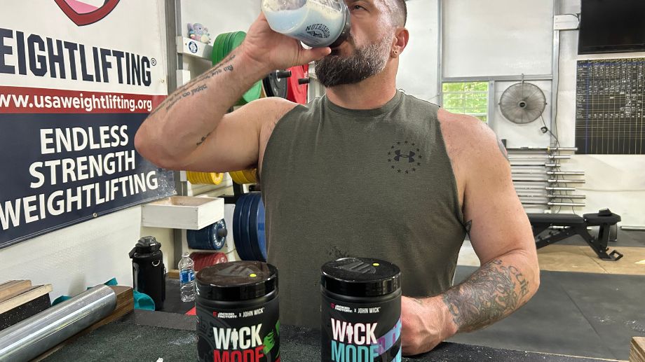 A man in a gym drinking Jacked Factory Wick Mode pre-workout